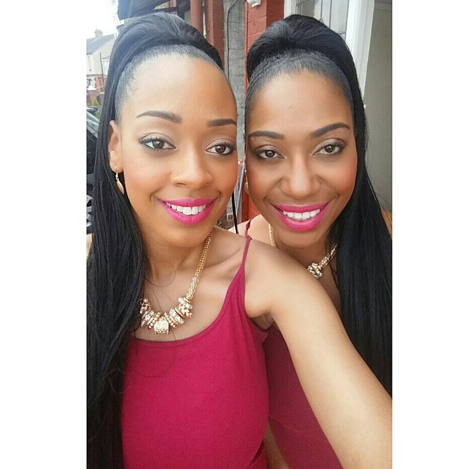 Twin sisters smiling for a selfie.