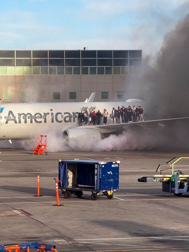 Passengers evacuating an American Airlines plane on the wing after a fire at Denver International Airport.