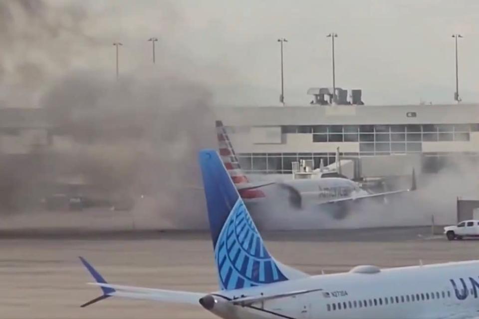 American Airlines plane on fire at Denver International Airport, emergency slides deployed.