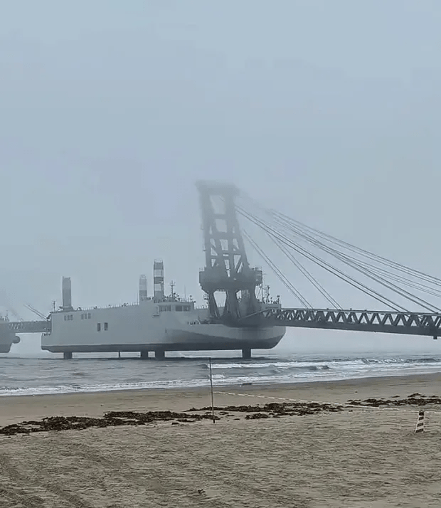 Large crane ship on the shore in foggy weather.