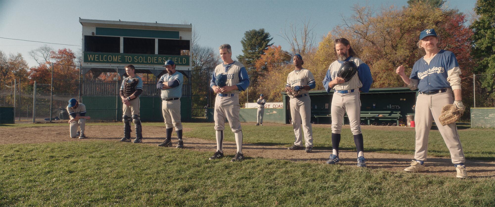 Men stand on a baseball field.