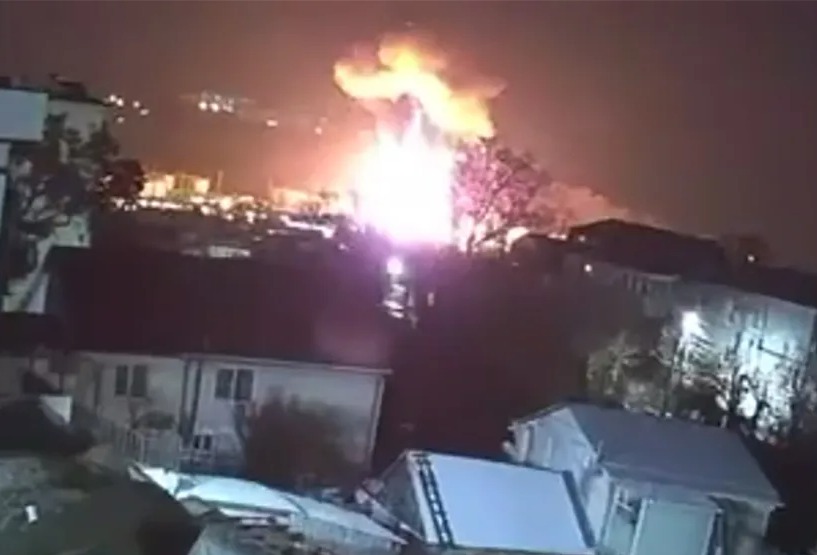 Nighttime security footage of a large fire and explosion, possibly at an oil refinery.