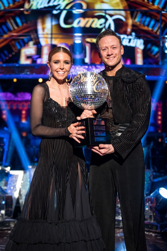 Stacey Dooley and Kevin Clifton holding the Strictly Come Dancing glitterball trophy.