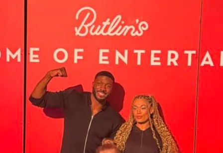 Family posing in front of a Butlin's sign.