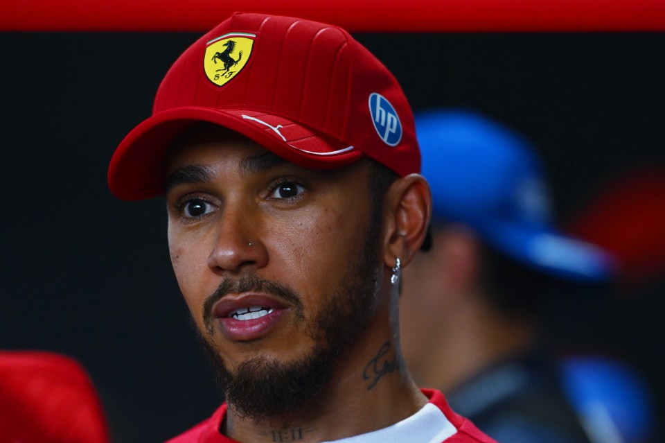 Lewis Hamilton wearing a red Ferrari hat.