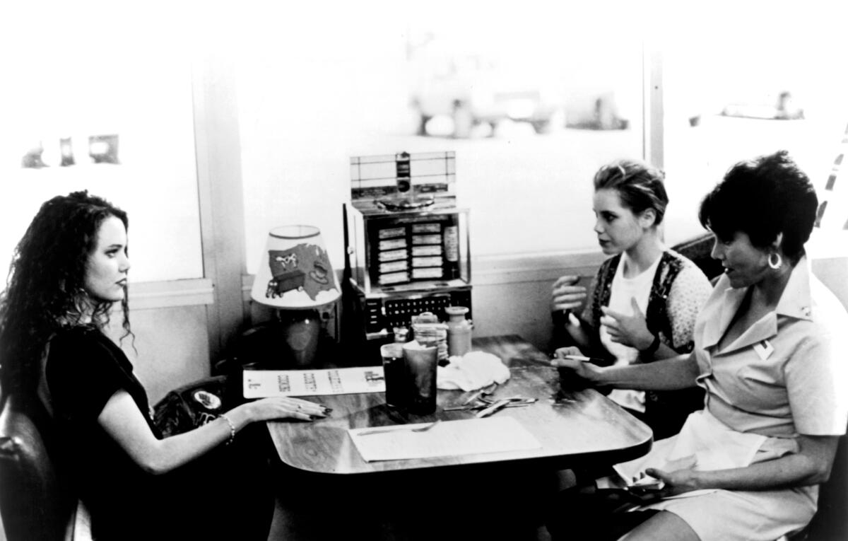 Three women sit in a diner booth.