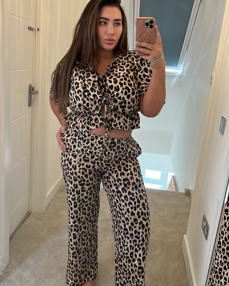 Woman in leopard print pants and top taking a selfie.