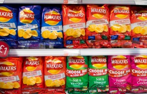 Supermarket shelf displaying multiple bags of Walkers crisps.