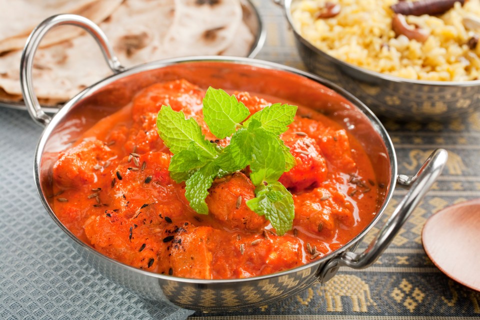 Chicken tikka masala in a bowl, garnished with mint.