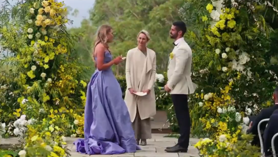 A wedding ceremony with the bride in a lavender gown.