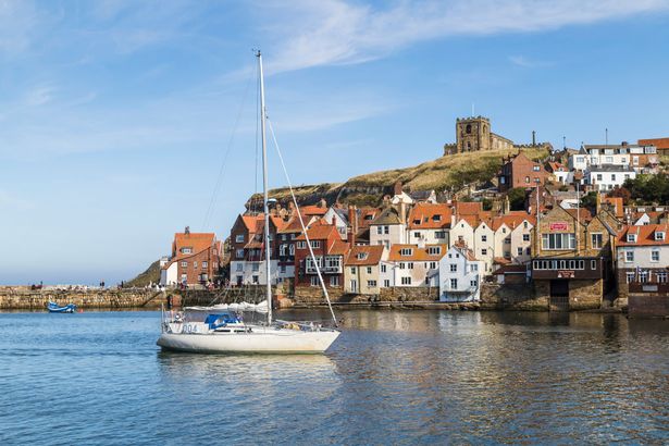 Yacht enters Whitby harbour under a blue sky. (Photo by: Jason Wells/Loop Images/Universal Images Group via Getty Images)