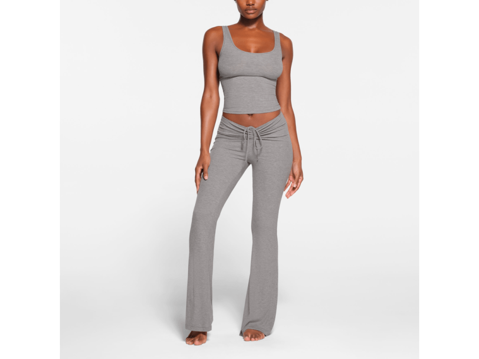 Woman modeling gray yoga top and pants.