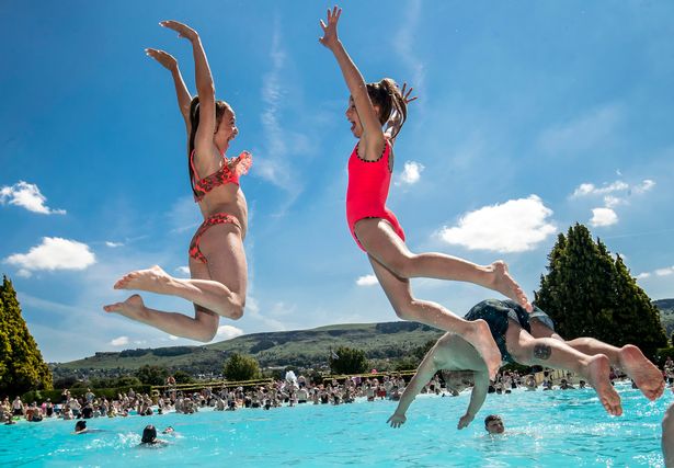 Sisters, Nyam May (left) and Ciara May (right), jump into the water at Ilkley outdoor pool and lido in West Yorkshire as the UK is expected to edge towards its hottest ever July day, with the mercury due to soar above 30C (86F). PRESS ASSOCIATION Photo. Picture date: Tuesday July 23, 2019. See PA story WEATHER Hot. Photo credit should read: Danny Lawson/PA Wire