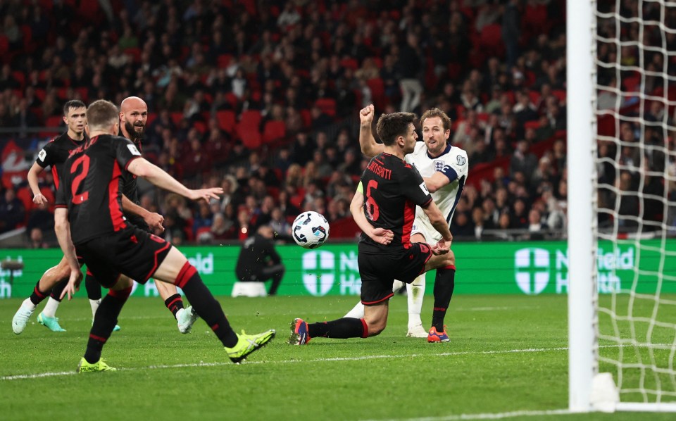 Harry Kane scoring a goal during a soccer match.