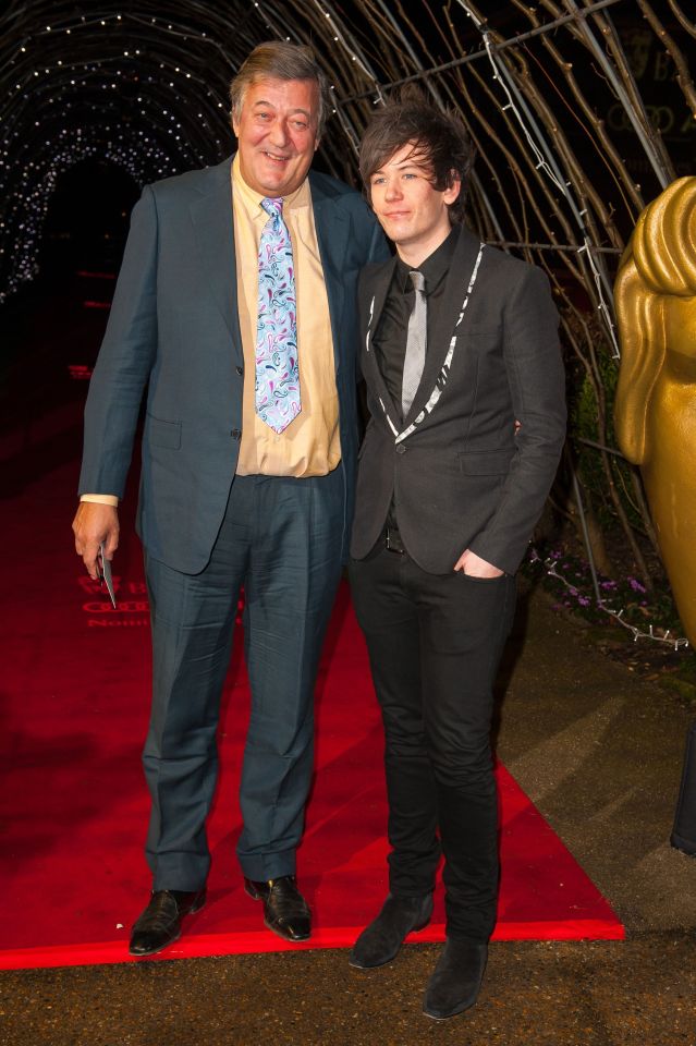 Stephen Fry and his husband Elliot Spencer on a red carpet.