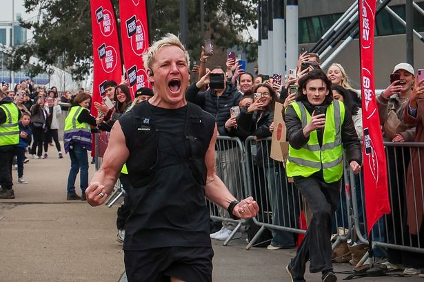 BBC Radio 1 presenter Jamie Laing celebrates at the finish line