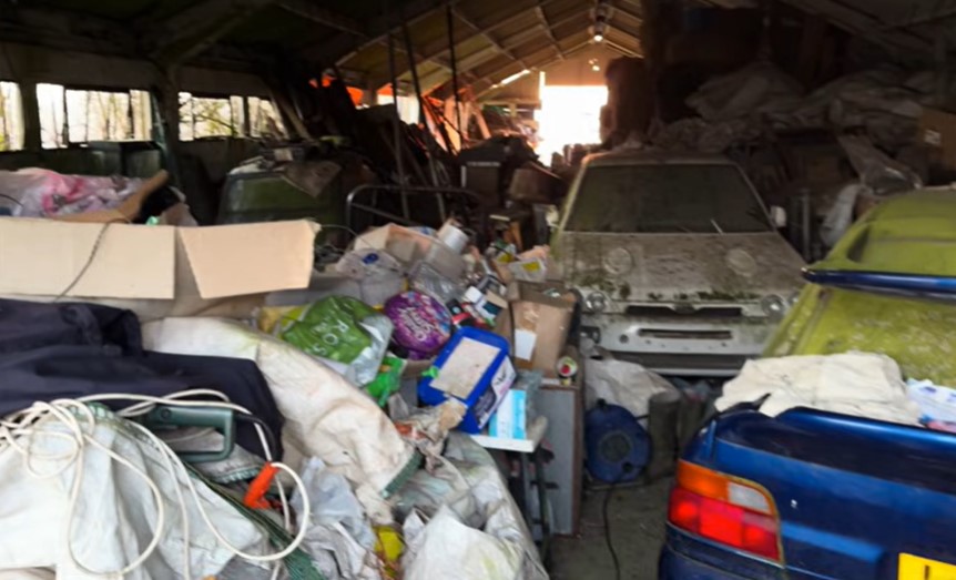 Barn find with several cars buried under debris.