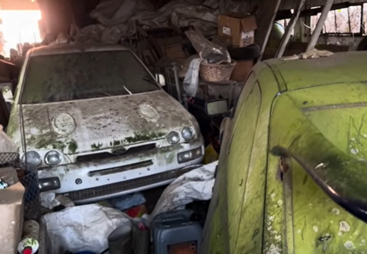 Barn find: a neglected Ford Escort Cosworth and another car covered in dust and debris.