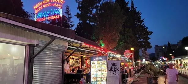 Malina pub in Sunny Beach at night, with neon signs lit up