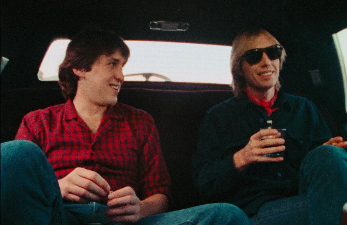 Cameron Crowe and Tom Petty sit in a car.