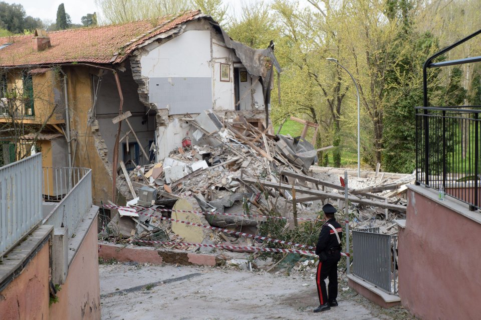 A Carabiniere guards the remains of a collapsed apartment building in Rome, Italy.