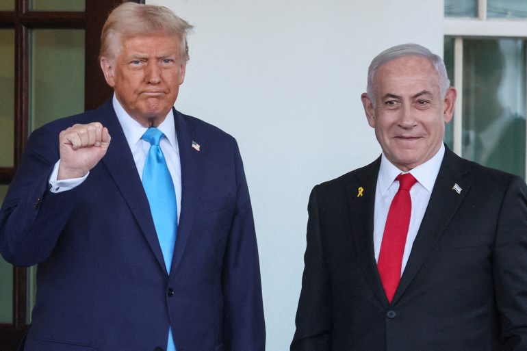 Donald Trump raises a fist as he stands next to Benjamin Netanyahu