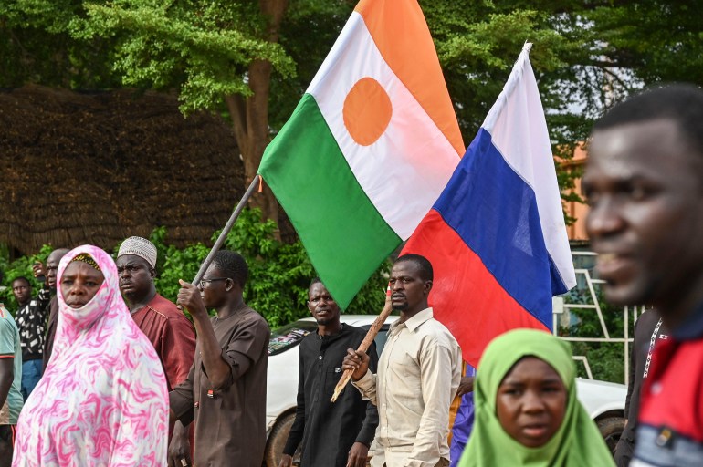 A picture of people in Niger carrying Nigerien and Russian flags.