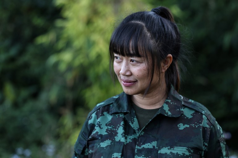 Olivia Thawng Luai, Chin National Defence Force (CNDF)'s defence secretary, is portrayed in a village at the frontline in Falam, Chin State, Myanmar, January 1, 2025. [Olivia Thawng Luai, Chin National Defence Force (CNDF)'s defence secretary, sits in front of the CNDF flag during an interview in a village at the frontline in Falam, Chin State, Myanmar, January 1, 2025 A Chin National Defence Force (CNDF) fighter stands on the ruins of a church bombed by a Myanmar military jet in Falam township, Chin State, Myanmar, December 31, 2024. [Valeria Mongelli/Al Jazeera]