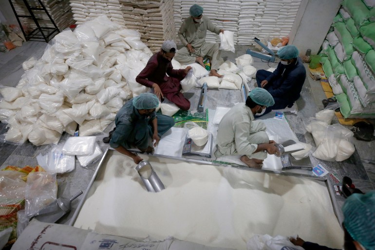 Workers of a charity group called "Alkhidmat Foundation Pakistan" prepare packets of sugar and other foodstuff to be distributed free among needy people for the upcoming Muslim fasting month of Ramadan, in Islamabad, Pakistan, Sunday, April 11, 2021. Ramadan begins with the new moon probably next week as Muslims around the world are trying to work out how to maintain the many cherished rituals of Islam's holiest month amid the coronavirus pandemic. (AP Photo/Anjum Naveed)