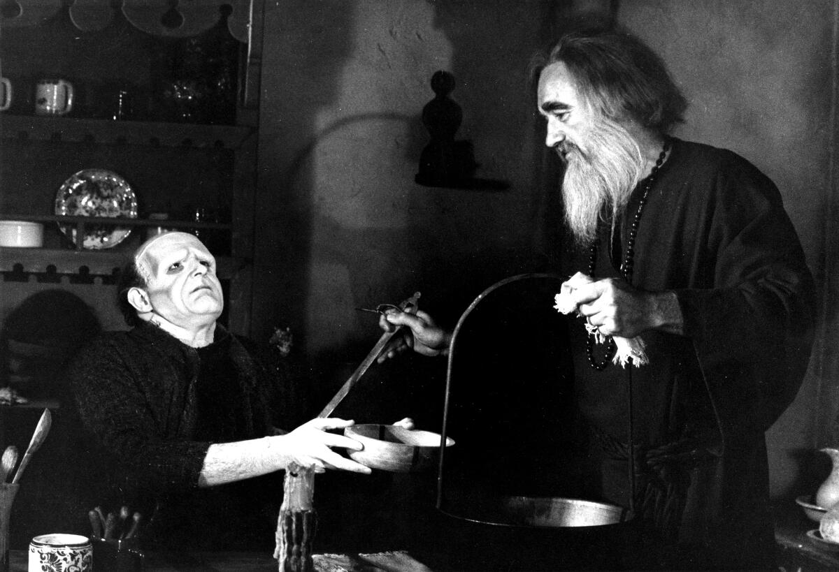 A blind man ladles hot soup into the lap of Frankenstein's monster, who holds out a bowl