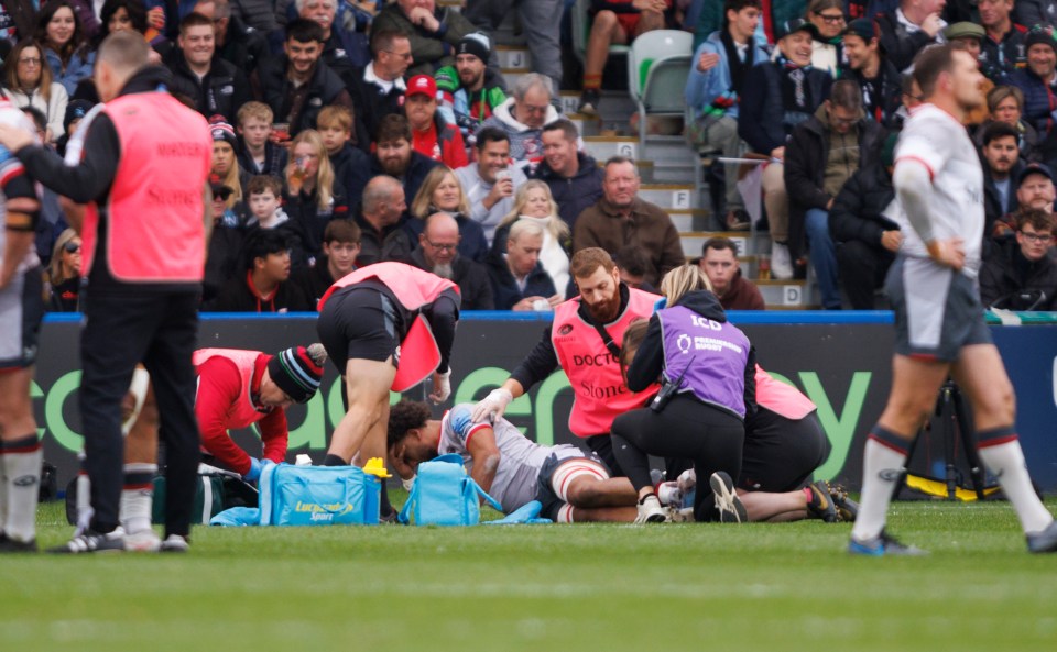 Rugby player receiving medical attention on the field.