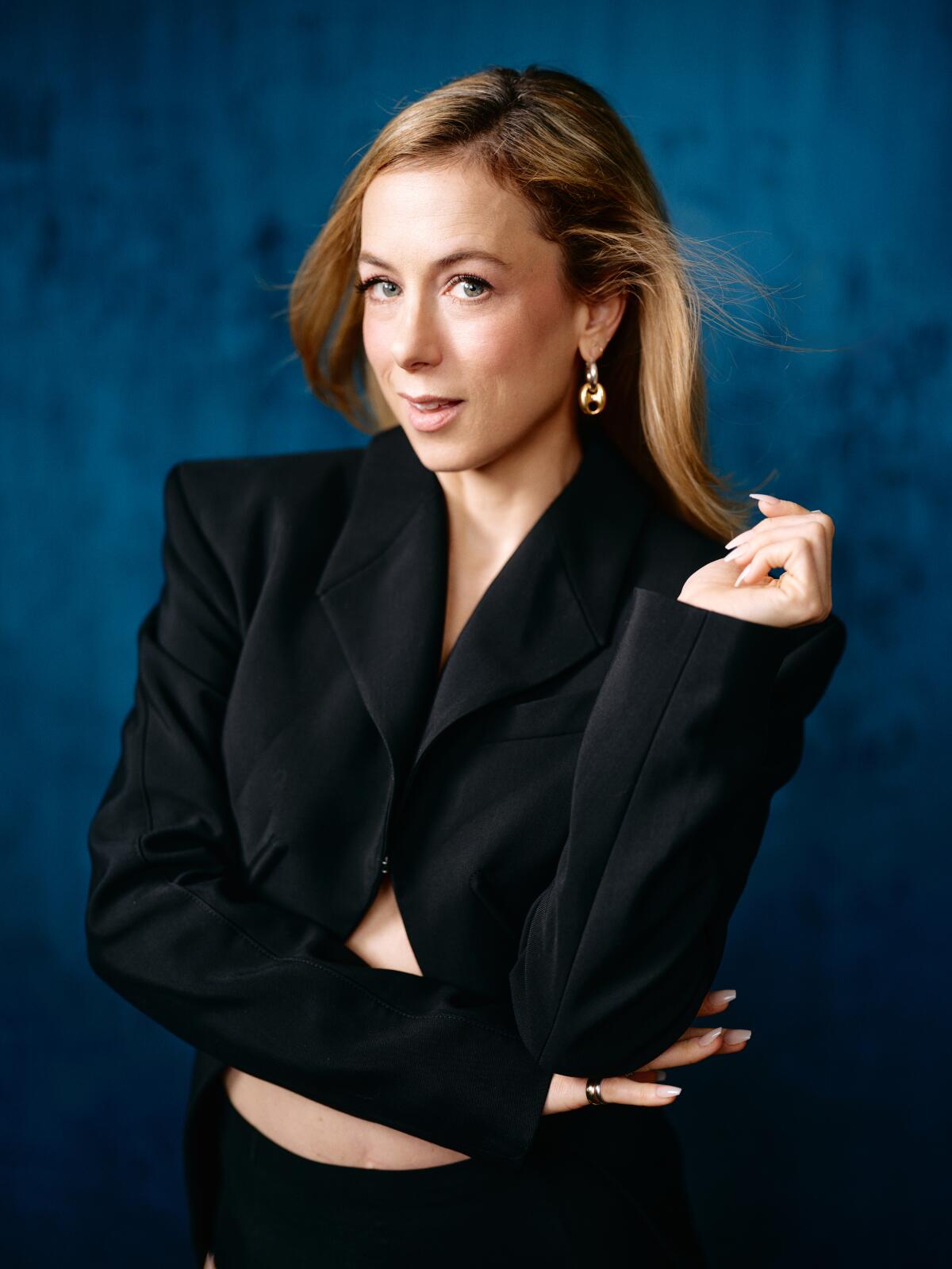 Portrait of comedian Iliza Shlesinger in a black jacket, looking sassy