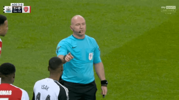 Referee giving a soccer player a warning.