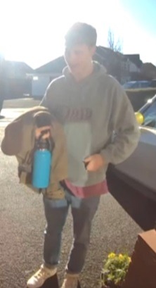 Person carrying a water bottle and jacket.