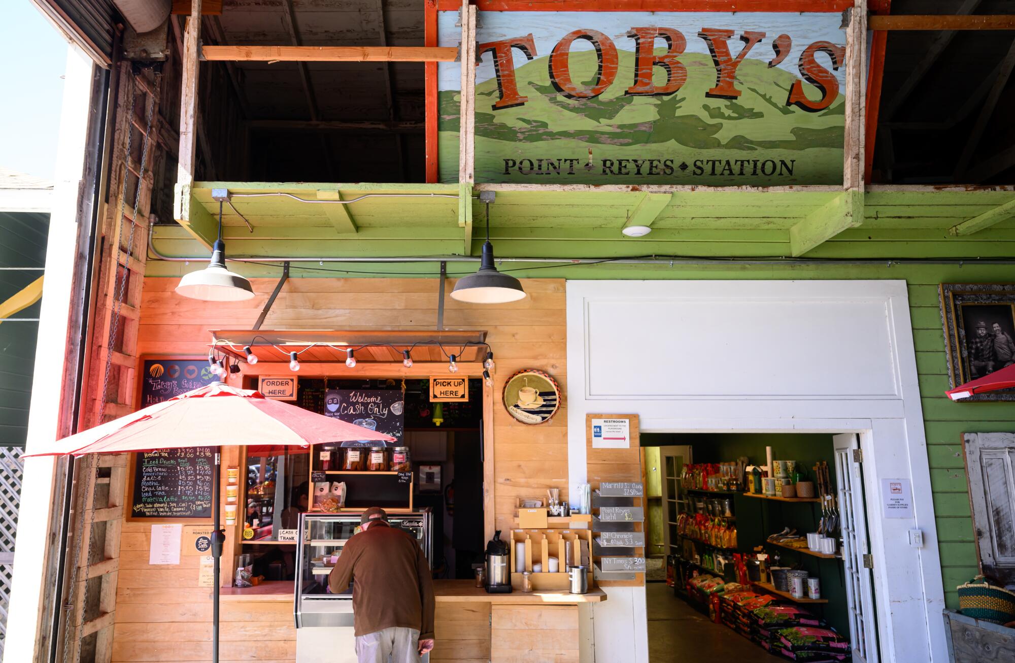 A patron places an order at a rustic coffee bar.