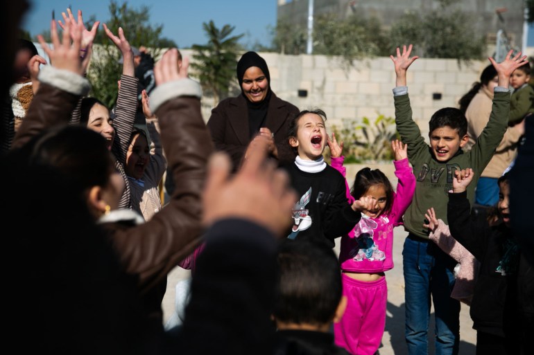 A group of children shouting as they participate in a Freedom Theater programme in Kafr Dan