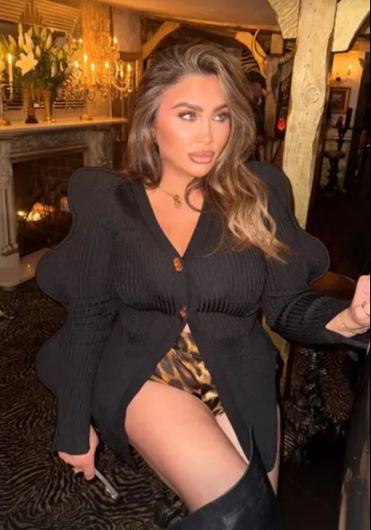 Lauren Goodger in a black cardigan and leopard print shorts.