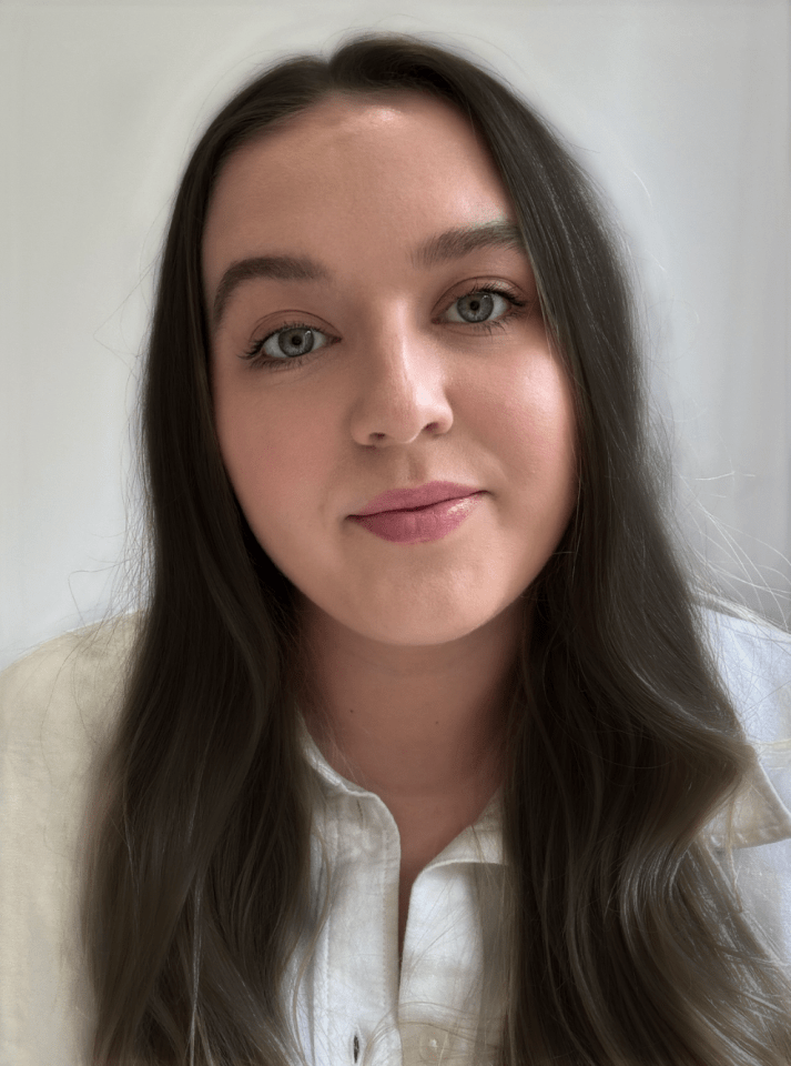 Portrait of a woman with long brown hair wearing a white shirt.