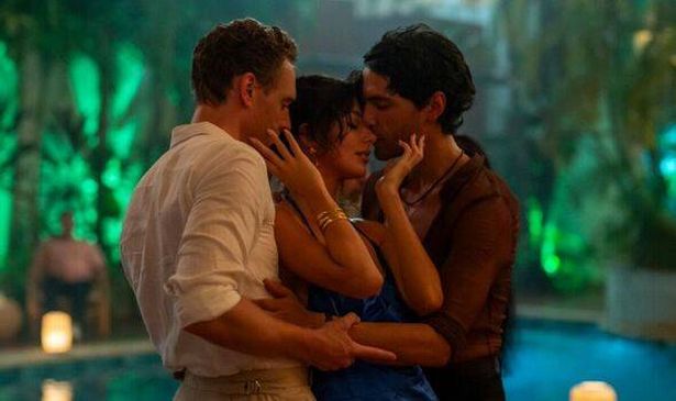 A woman dancing between two men