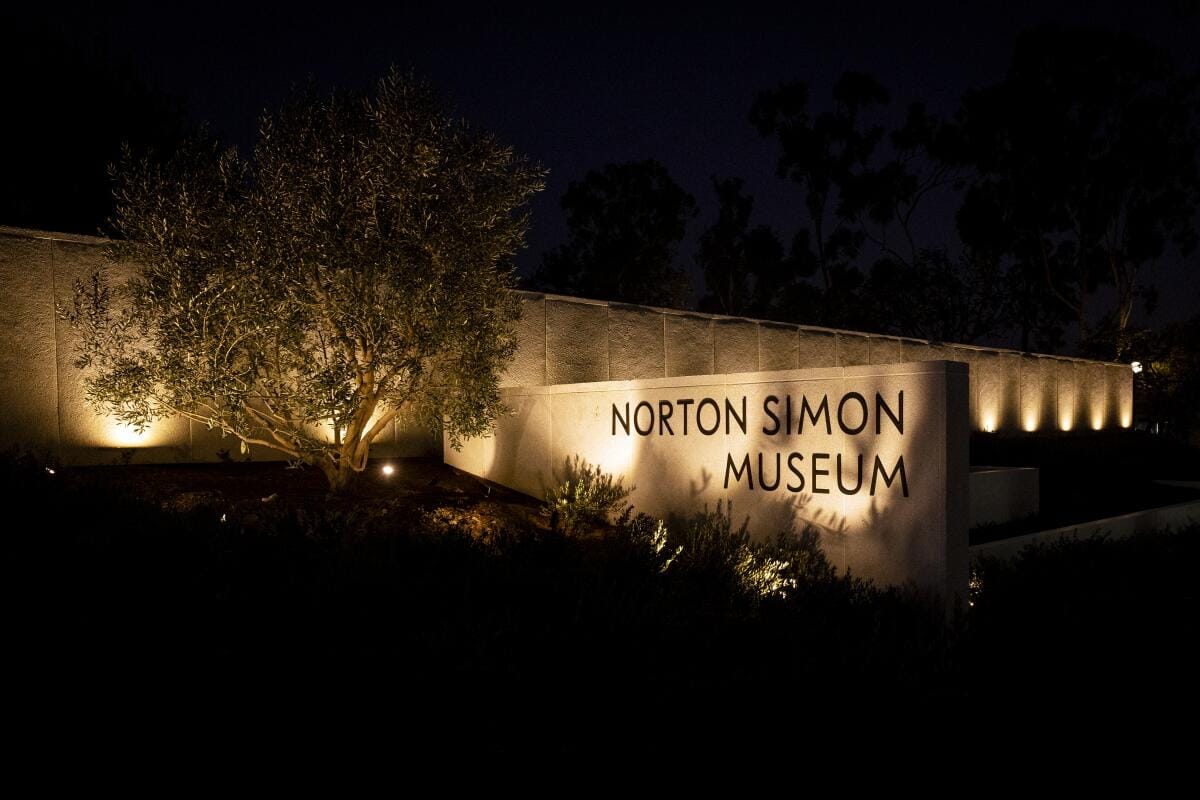Signage, illuminated at night, at the entrance of the Norton Simon Museum.
