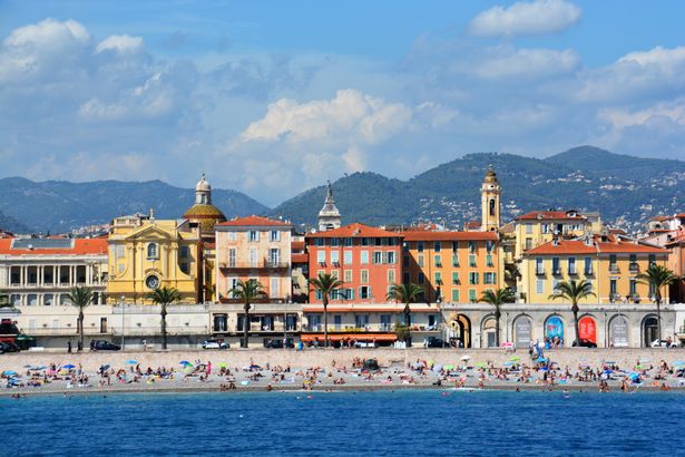 A view of the Promenade des Anglais, the mountains , the beach  and its beautiful buildings.