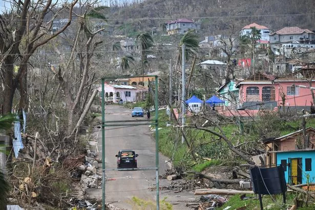A vehicle drives through a damaged area in St Elizabeth, Jamaica, on October 31, 2025, in the aftermath of Hurricane Melissa.
