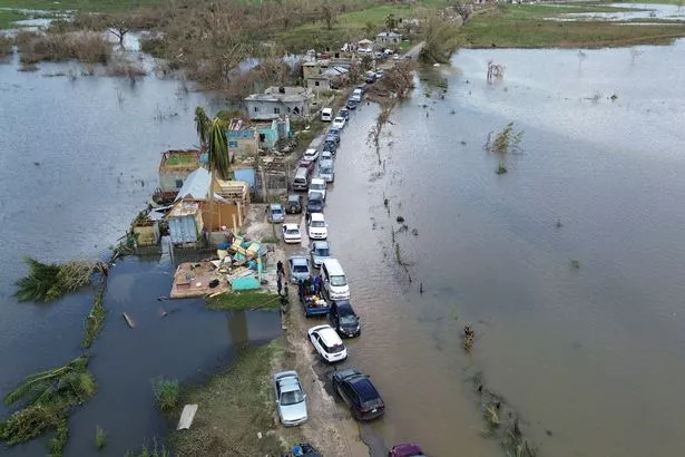 An aerial view shows cars and damaged property in a flooded section of road from Holland Bamboo to Middle Quarters in St Elizabeth, Jamaica, on October 31, 2025, in the aftermath of Hurricane Melissa