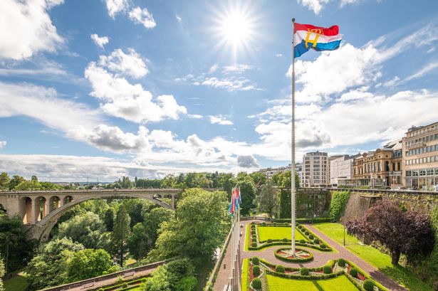 This is a phot of a tall flag pole with the flag of Luxembourg with the Henri's (the Duke) monogram. It is displayed on the Duke's birthday.