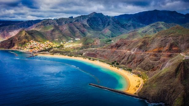 view of the coast of the paradise island of Tenerife with crystal clear and turquoise water and blue sky with drone. Teresitas beach