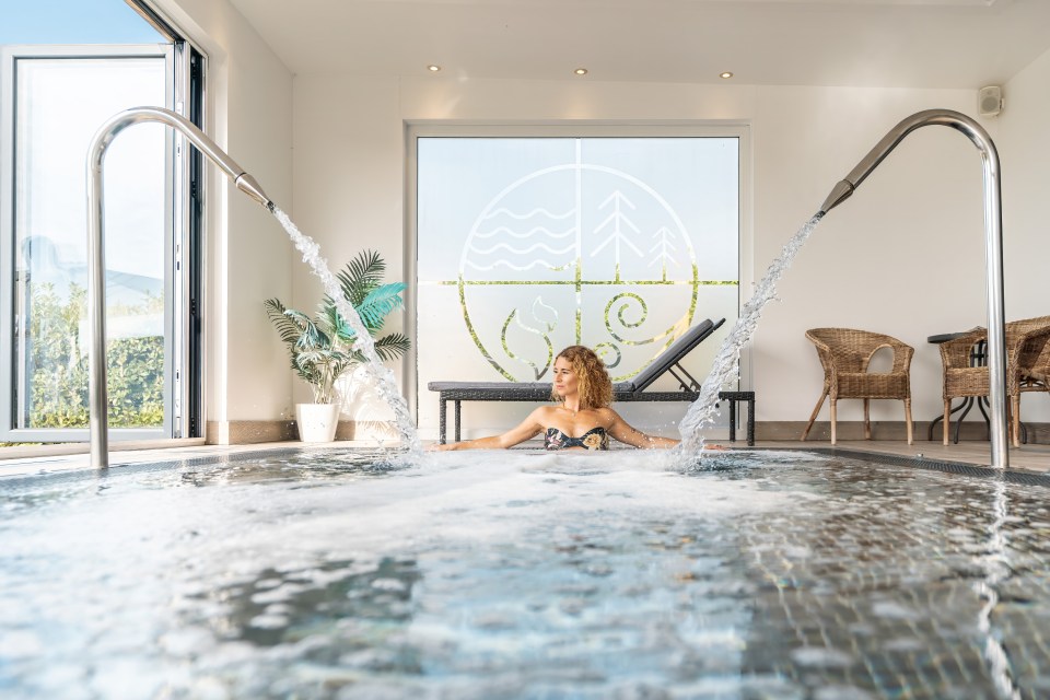 Woman in a swimsuit in a spa pool with water jets.