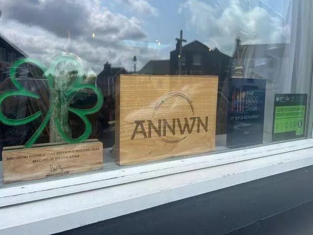 A sign for Annwn in a shop window