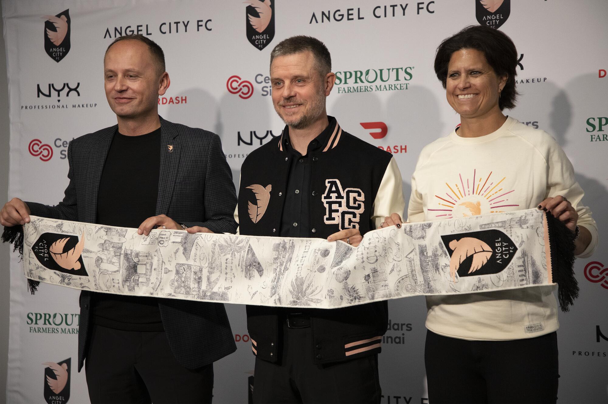 Alexander Straus, center, is introduced as Angel City coach by Mark Parsons, left, and Julie Uhrman.
