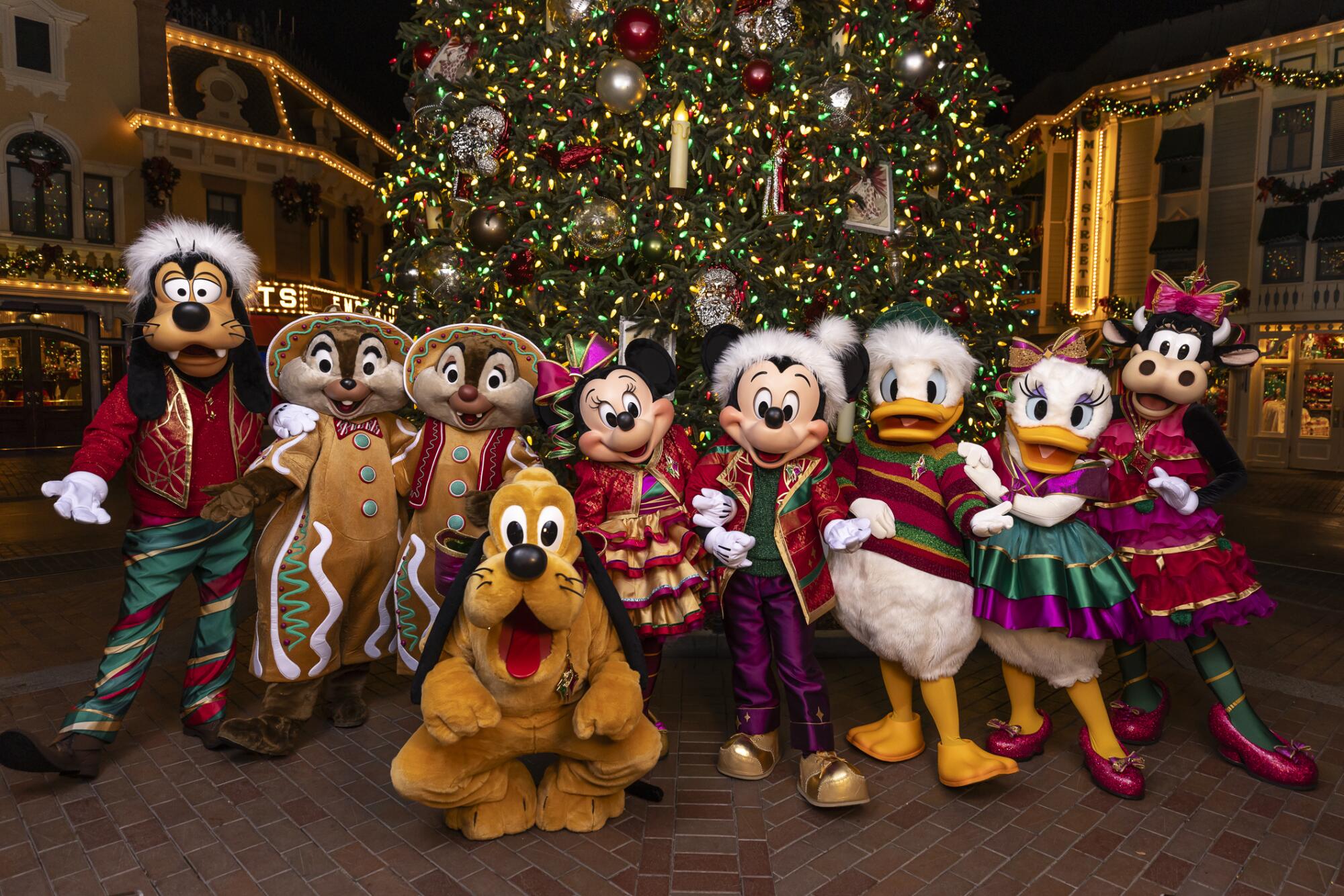 Mickey, Minnie and friends in front of a Christmas tree at Disneyland. 