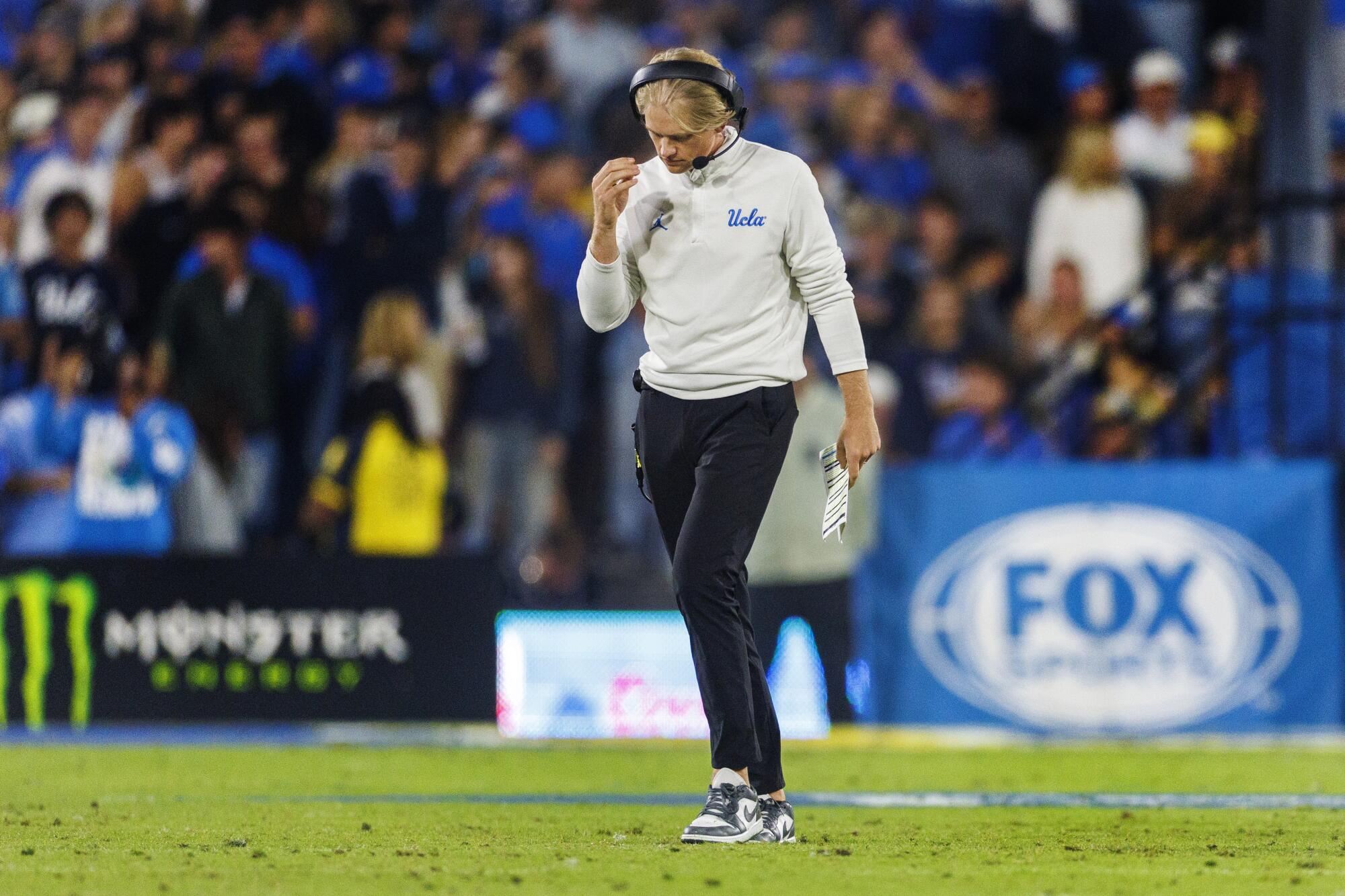UCLA offensive coordinator Jerry Neuheisel walks back to the sidelines after a timeout at the Rose Bowl.